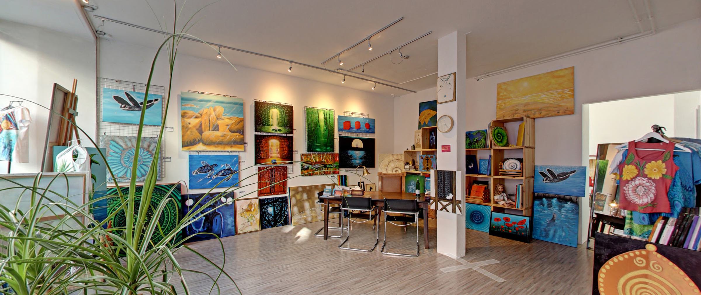 Blick in die Imago Endo Atelier Galerie mit vielen farbigen Gemälden an den Wänden